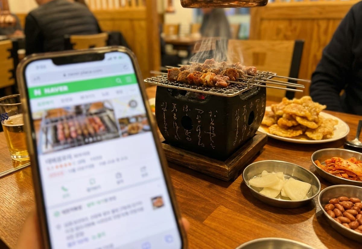 반포양꼬치 매장에서 네이버 플레이스 화면을 확인하는 모습